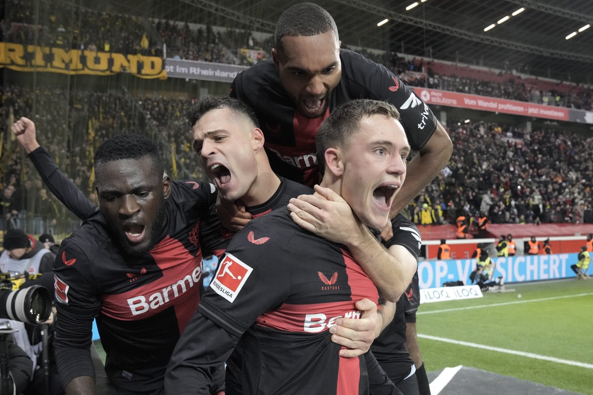 Leverkusen's Florian Wirtz, right, celebrates with teammates Jonathan Tah, up, Victor Boniface, left, and Granit Xhaka, center, after scoring a goal that was seconds later disallowed by a VAR dec ...