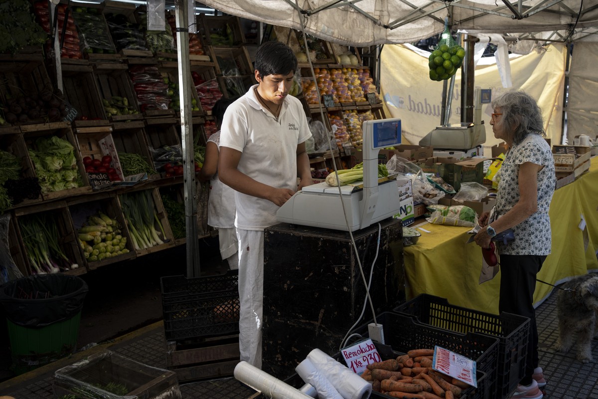 A vendor attends a shopper at a government subsidized food market set up once a week in neighborhoods across Buenos Aires, Argentina, Monday, Dec. 11, 2023. South America's second largest economy ...