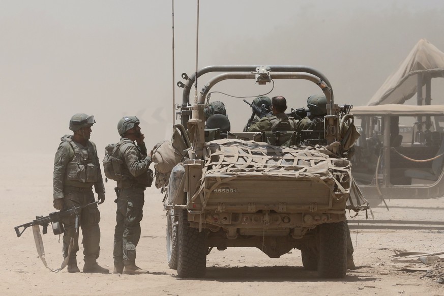 epa11452020 Israeli soldiers with a military vehicle at an undisclosed location near the border with the Gaza Strip, southern Israel, 02 July 2024. The Israeli military stated on 02 July that it conti ...