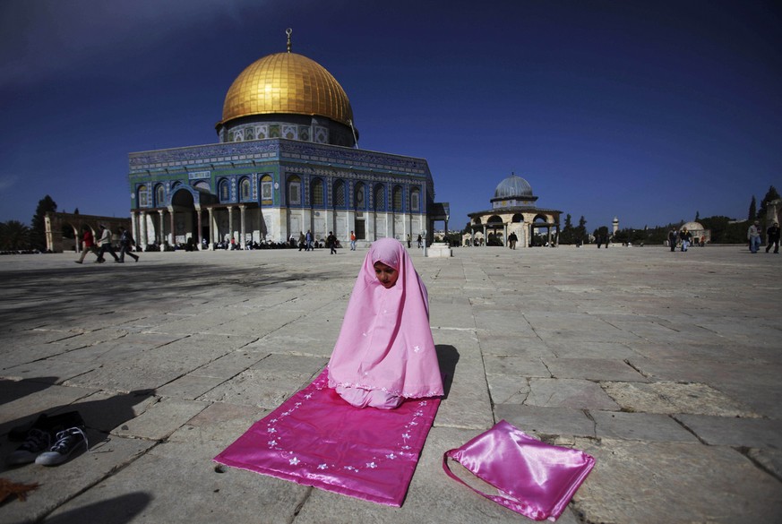 The Dome of the Rock Mosque is seen in the background as a young Palestinian Muslim worshipper prays during Friday noon prayer in the Al Aqsa Mosque compound in Jerusalem's Old City, Friday, Jan. 30,  ...