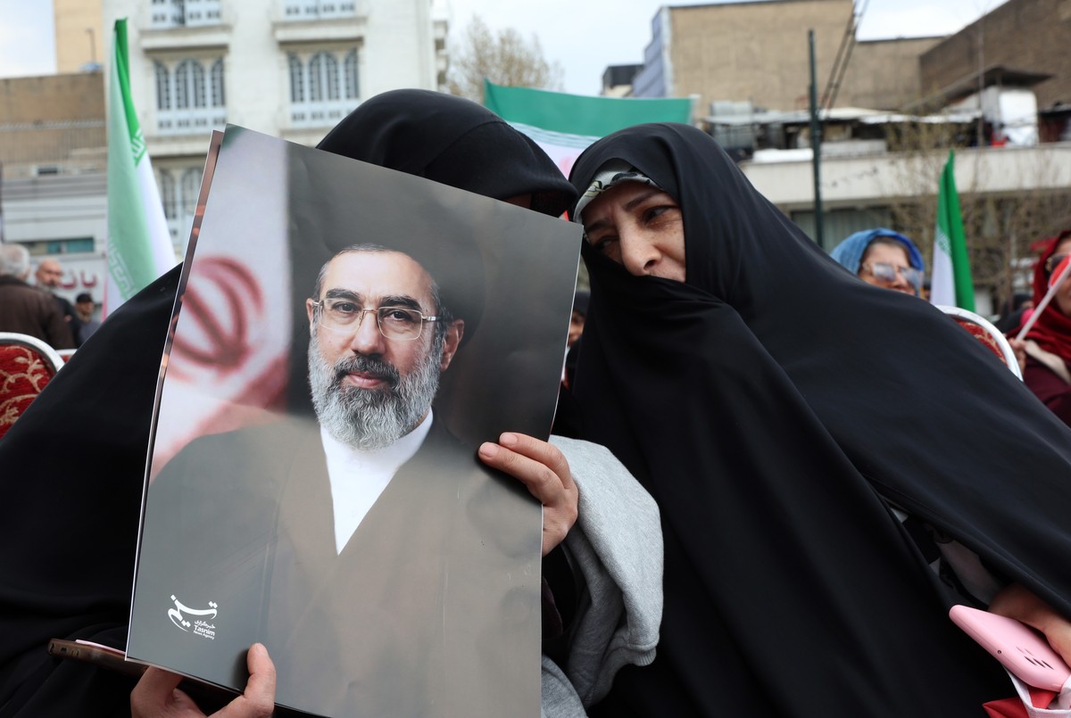 epa12866126 An Iranian woman clad in a black chador hold a poster of Iranian Supreme Leader Ayatollah Mojtaba Khamenei during the annual 'Sizdah Bedar' (Nature Day) festival in Tehran, Iran, ...