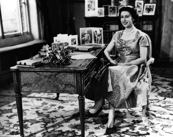 25th December 1957: Queen Elizabeth II smiling towards The Prince Philip, Duke of Edinburgh just before the end of her first Christmas Day television speech to her nation.