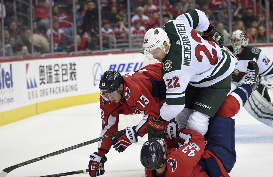Minnesota Wild right wing Nino Niederreiter (22) collides with Washington Capitals left wing Jakub Vrana (13), of the Czech Republic, and right wing Tom Wilson (43) during the second period of an NHL  ...