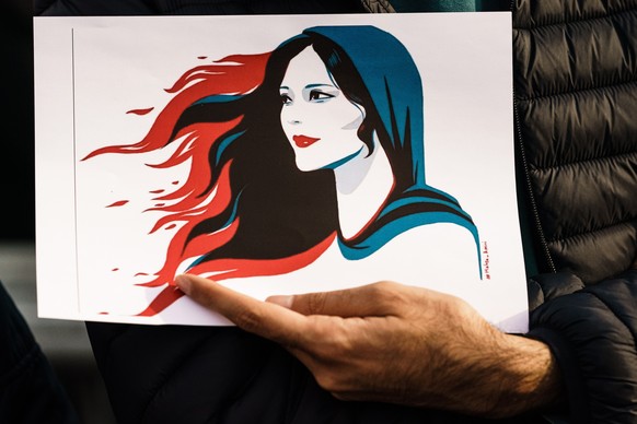 epa10201920 A participant holds an illustration showing Mahsa Amini during a rally in Berlin, Germany, 23 September 2022. Iran has faced many anti-government protests following the death of Mahsa Amin ...
