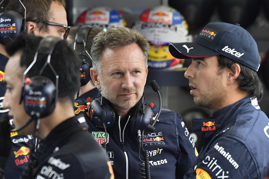 Team chief Christian Horner of Red Bull Racing, center, speaks with Red Bull driver Sergio Perez of Mexico prior to the qualifying session ahead of the Formula One Grand Prix at the Spa-Francorchamps  ...