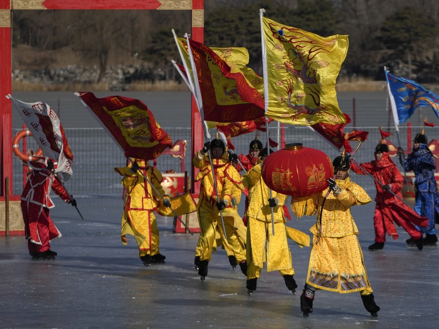 Chinese artists dressed in traditional costume perform an ice frolic on a frozen lake at the Yuanmingyuan Garden during the second day of the Lunar New Year celebrations in Beijing, Monday, Jan. 23, 2 ...