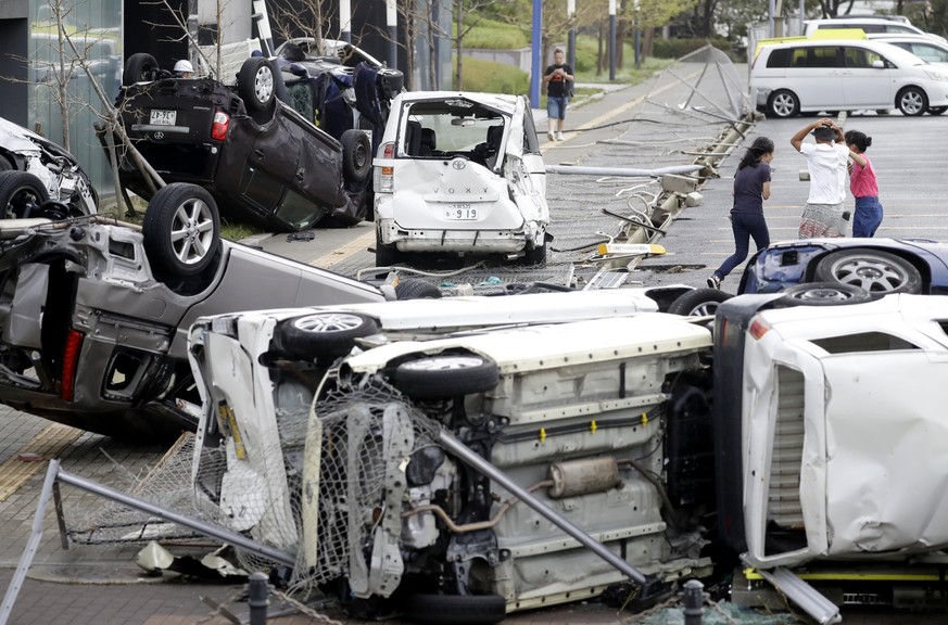 Overturned cars are seen on street following a powerful typhoon in Osaka, western Japan, Tuesday, Sept. 4, 2018. A powerful typhoon blew through western Japan on Tuesday, causing heavy rain to flood t ...