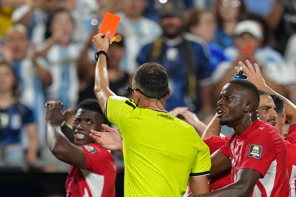 Referee Joao Pinheiro, of Portugal, gives a red card to Switzerland's Breel Embolo (7), left, during the World Cup quarterfinal soccer match between Argentina and Switzerland in Kansas City, Mo., ...