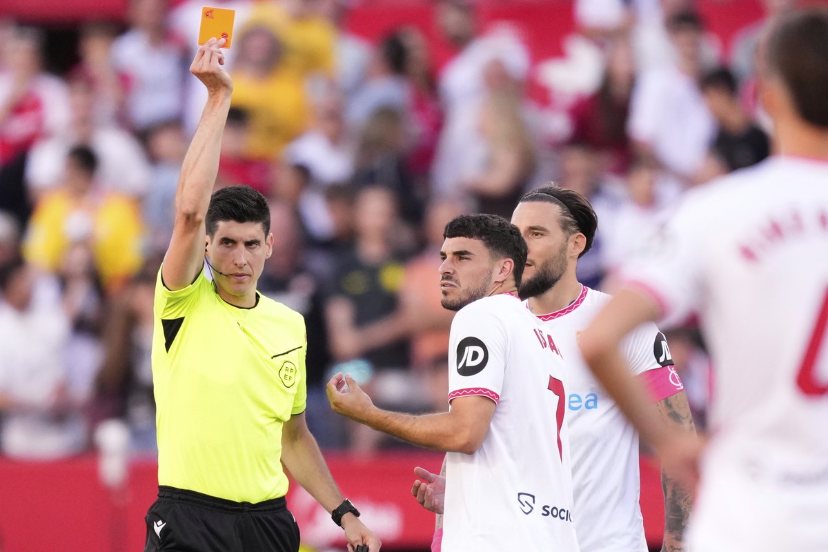 Referee Mateo Busquets Ferrer shows a red card to Sevilla's Isaac Romero, centre, during the Spanish La Liga soccer match between Sevilla and Real Madrid at the Ramon Sanchez Pizjuan stadium in S ...