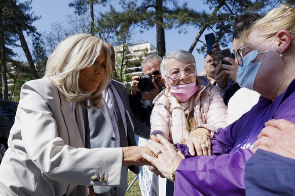 epa09906510 Brigitte Macron, wife of French President and candidate for re-election, greets supporters after voting in the second round of the 2022 French presidential election, at a polling station i ...