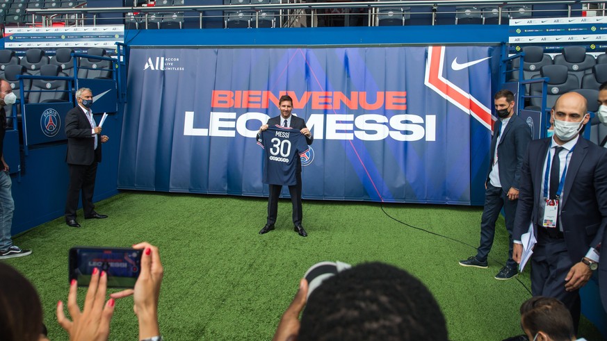 epa09409541 Argentinian striker Lionel Messi poses with his new PSG jersey after his press conference as part of his official presentation at the Parc des Princes stadium, in Paris, France, 11 August  ...