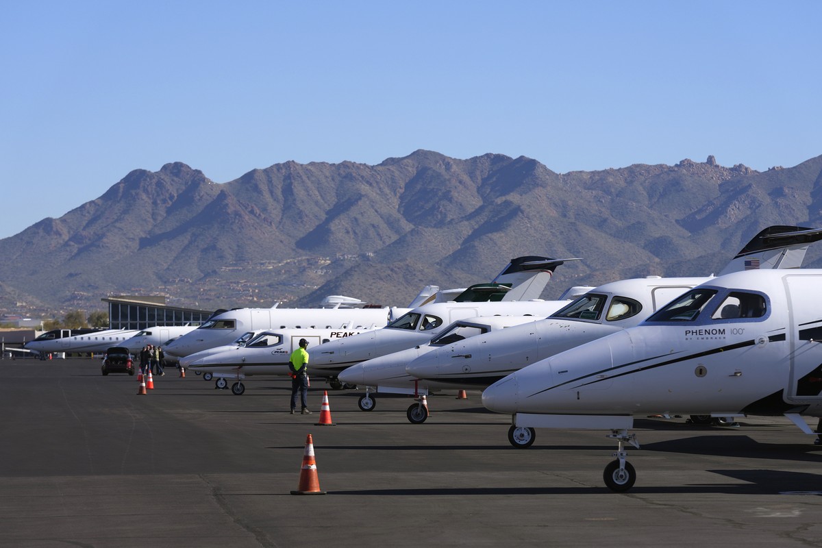 A Scottsdale Airport staffer waits on a private jet, as the airport gears up for the expected dramactic increase in private jet traffic, leading up to the NFL Super Bowl LVII football game at Scottsda ...