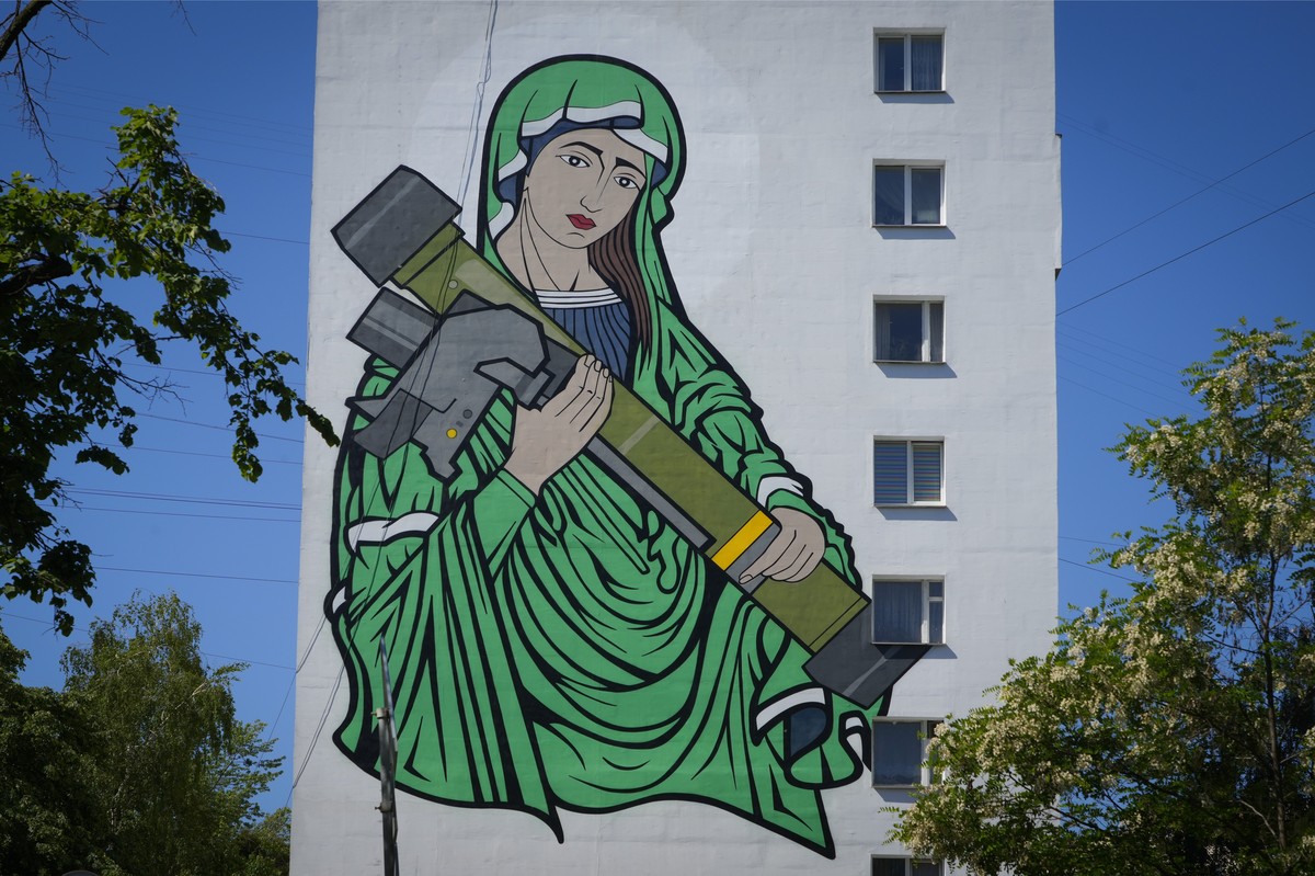 A mural depicts an image known as "Saint Javelina"- Virgin Mary cradling a US-made FGM-148 anti-tank weapon Javelin - on a living house wall in Kyiv, Ukraine, Monday, June 6, 2022. These mis ...