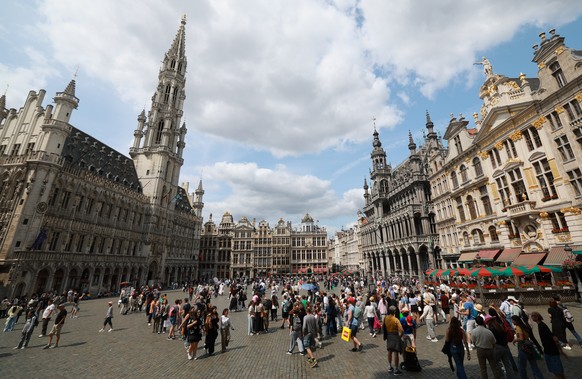 epa12286570 Tourists visit the Grand Place of Brussels with famous tower of City Hall in Brussels, Belgium, 06 August 2025. EPA/OLIVIER HOSLET