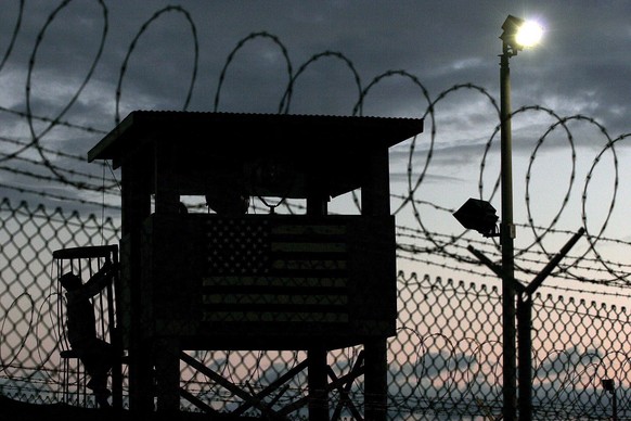 epa05177020 (FILE) A file photograph dated 16 February 2006, showing a Joint Task Force member climbing to his guard tower post surrounded by triple rows of razor barbed wire that perimeter the securi ...