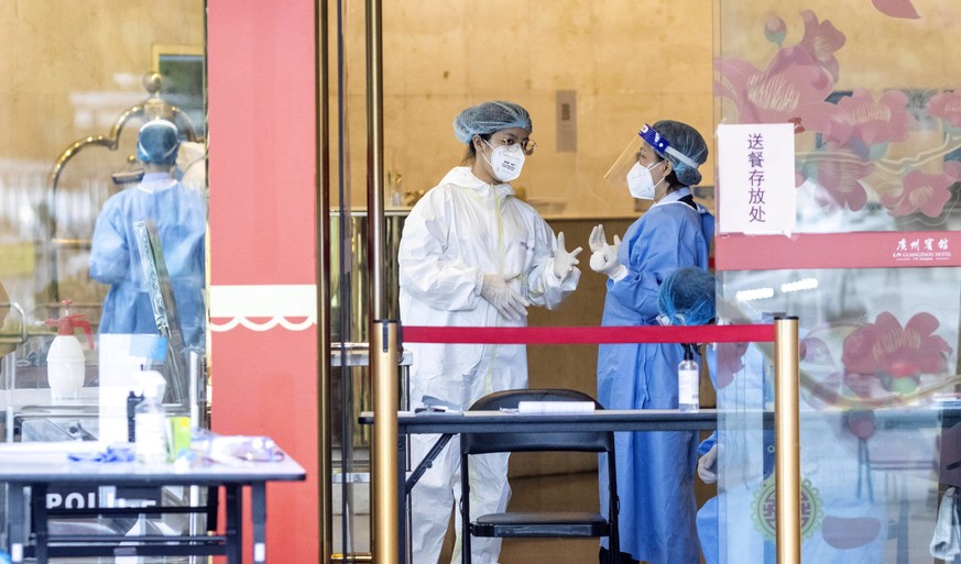 epa08379062 Personal wearing protective gear at the entrance of a hotel in Guangzhou, Guangdong province, China, 23 April 2020. The outbreak of novel coronavirus, which causes the infection COVID-19,  ...