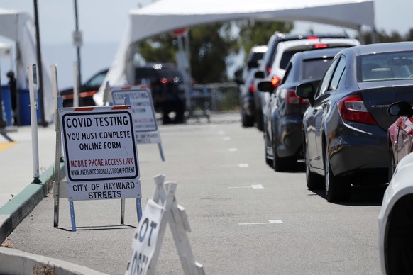 epa08524049 Vehicles line up at a drive-through COVID-19 makeshift testing facility operated by the Hayward Fire Department on the California State University East Bay campus in Hayward, California, U ...