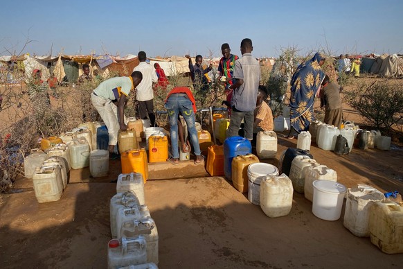 Sudanese men who fled el-Fasher city, after Sudan&#039;s paramilitary forces killed hundreds of people in the western Darfur region, collect water at a camp in Tawila, Sudan, Saturday, Nov. 1, 2025. ( ...