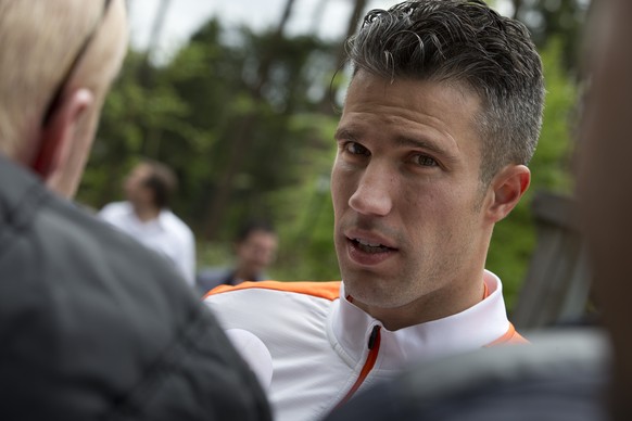 Manchester United player Robin van Persie, and captain of the Dutch soccer team, answers questions of reporters after a team training session in Hoenderloo, eastern Netherlands, Thursday, May 15, 2014 ...