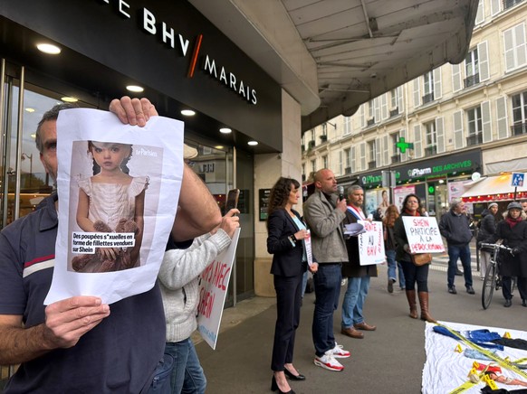 KEYPIX - A protester holds a picture of a childlike sex doll outside BHV Marais department store in Paris, Monday, Nov. 3, 2025, where Shein is due to open its first permanent physical store world wid ...