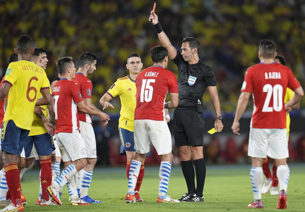 Referee Facundo Tello awards a red card to Paraguay's Hernan Perez, third from left, as teammate Gustavo Gomez, center, protests during a qualifying soccer match for the FIFA World Cup Qatar 2022 ...