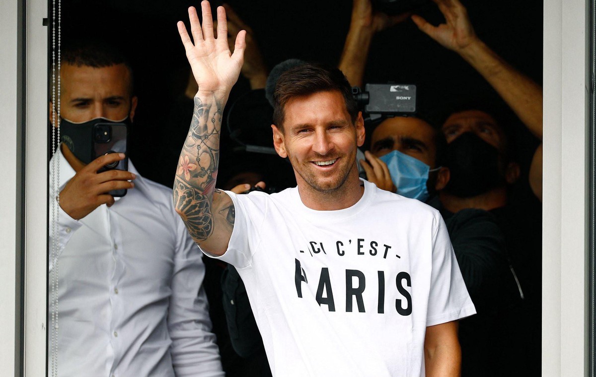 Lionel Messi winkt bei seiner Ankunft in Paris den Fans zu.