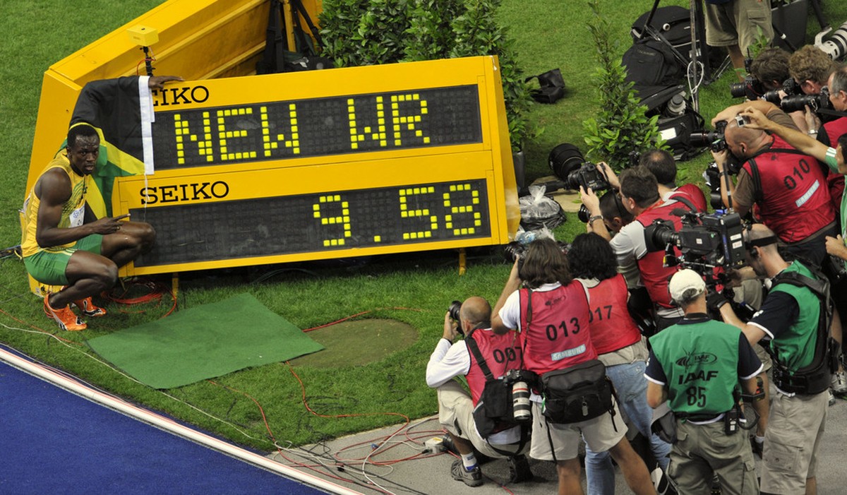 Jamaica's Usain Bolt poses beside the indicating board after setting a new Men's 100m World Record in the Men's final at the World Athletics Championships in Berlin on Sunday, Aug. 16,  ...