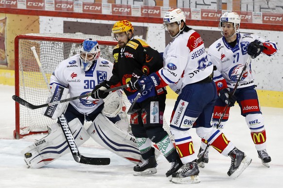 Zuerichs Goalie Lukas Flueeler, Berns Topscorer Mark Arcobello, Zuerichs Jonas Siegenthaler und Ryan Shannon, von links, im Eishockey Meisterschaftsspiel der National League A zwischen dem SC Bern und ...