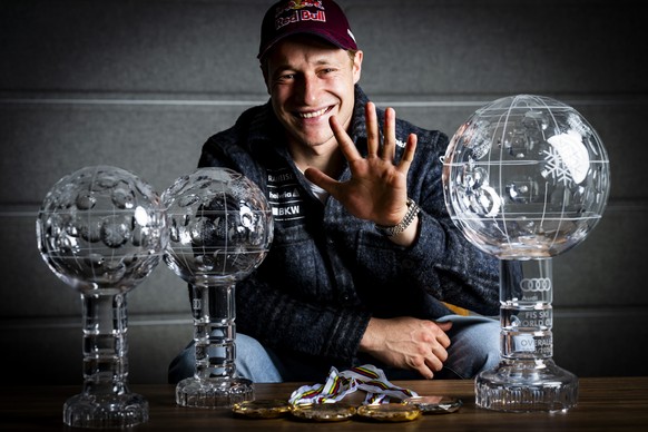 Marco Odermatt of Switzerland poses with the men's overall crystal globe trophy, the men's Super-G overall leader crystal globe trophy and the men's Downhill overall leader crystal glob ...