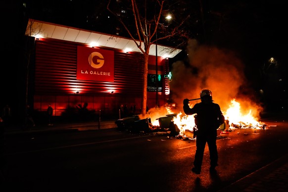 epa10530971 Protesters set fire to a barricade during a protest against the pension reform law in Paris, France, 18 March 2023. A thousands of people demonstrate in Paris after French Prime Minister E ...