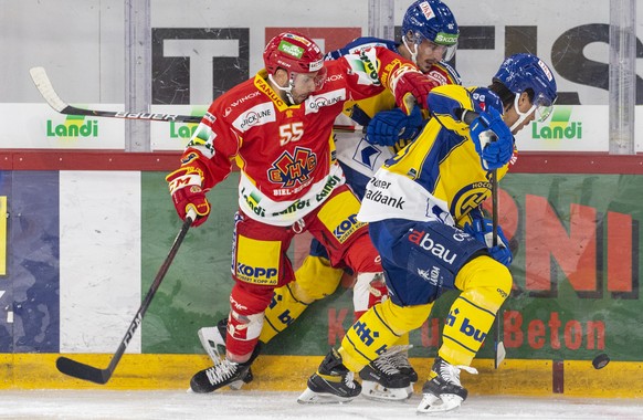 Biels Riccardo Sartori, links, kaempft um den Puck gegen die Davos-Spieler Marc Wieser, Mitte, und Samuel Guerra, rechts, waehrend einem Vorbereitungsspiel der National League zwischen dem EHC Biel un ...