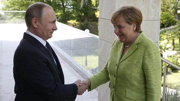 Russian President Vladimir Putin, left, and German Chancellor Angela Merkel shake hands prior to their talks at Putin&#039;s residence in the Russian Black Sea resort of Sochi, Russia, Tuesday, May 2, ...