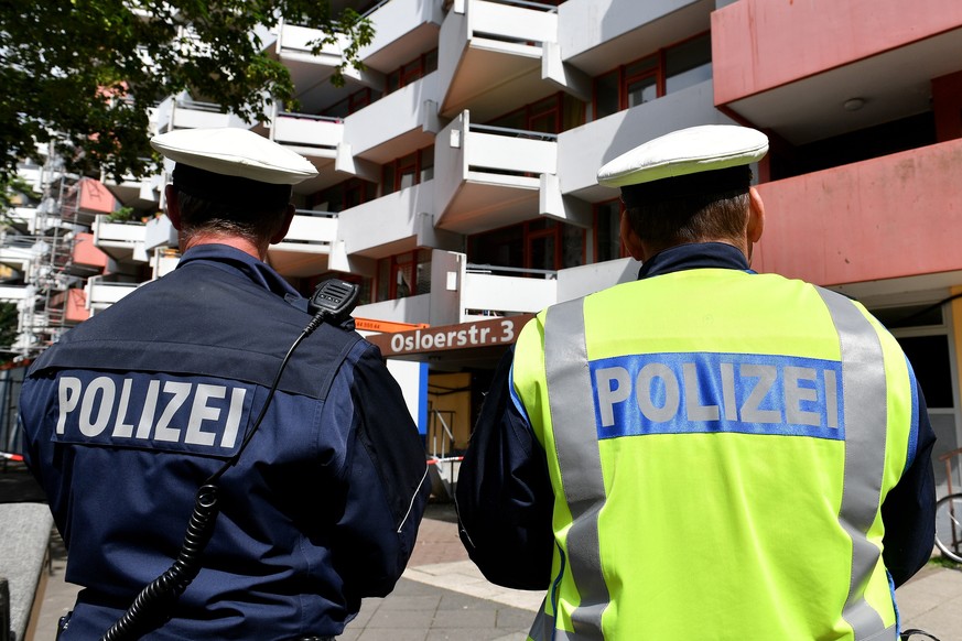 epa06805073 Police officers stand guard in front of an apartment block in the Chorweiler district of Cologne, Germany, 13 June 2018. During a German special forces raid late 12 June evening police had ...