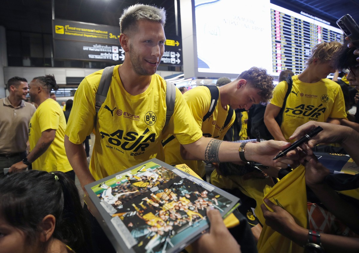 epa11488768 Borussia Dortmund player Niklas Sule signs autographs for fans during the team's arrival at Don Mueang International Airport in Bangkok, Thailand, 20 July 2024. German Bundesliga socc ...