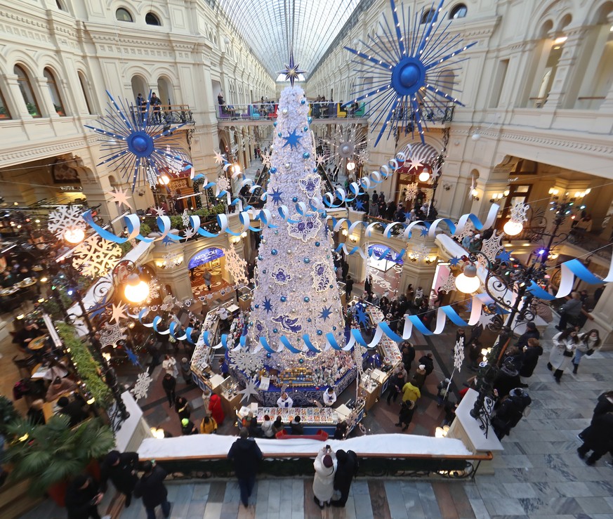 epa10347773 People walk in front of a Christmas tree in the GUM Department Store decorated for Christmas and the New Year on the Red Square in downtown of Moscow, Russia, 04 December 2022. Russians ar ...