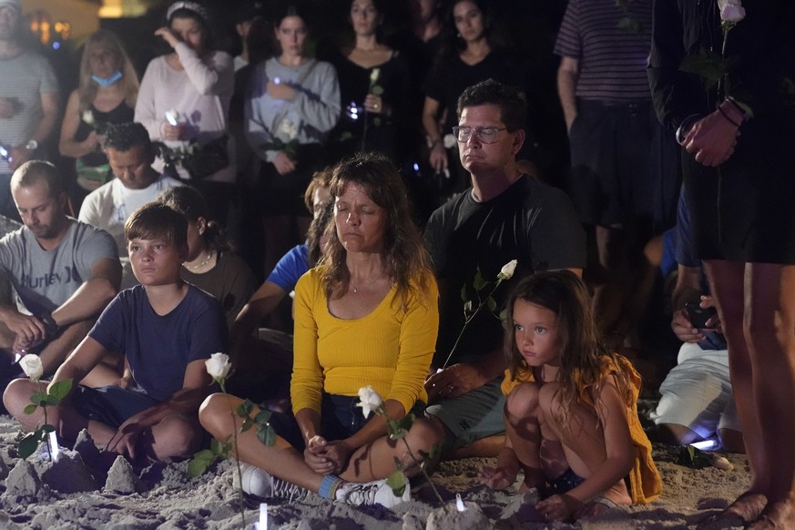 People gather at a vigil, late Monday, June 28, 2021, in Surfside, Fla. The vigil remembered those that died, are missing and those injured after a residential building collapsed last Thursday. (AP Ph ...