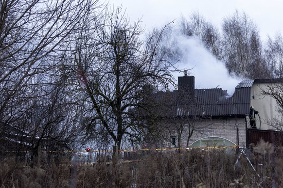 A smoke rises from the site where a DHL cargo plane crashed into a house near Vilnius, Lithuania, Monday, Nov. 25, 2024. (AP Photo/Mindaugas Kulbis)