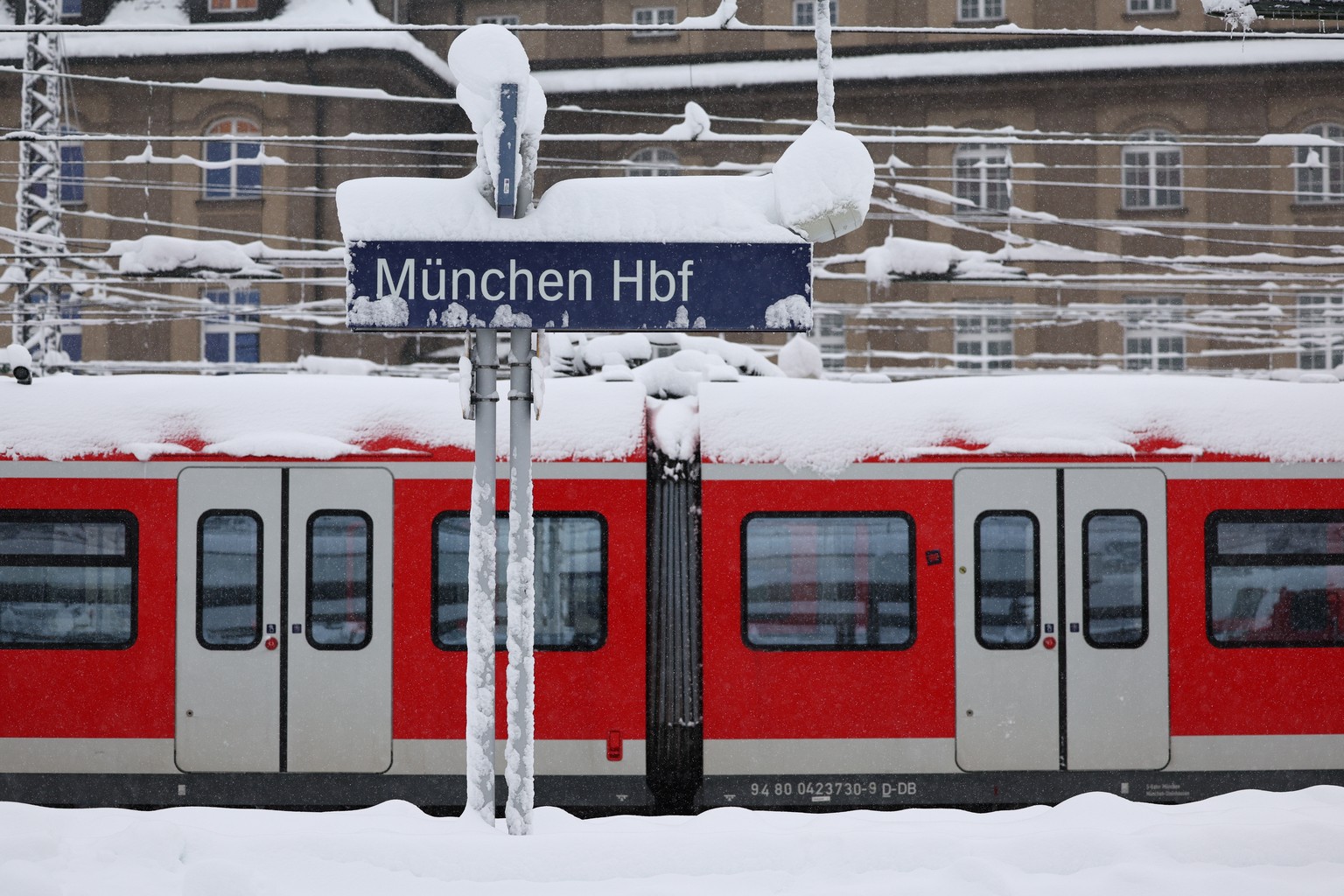 epa11007116 A view of a snow-covered train parked at Munich central station in Munich, Germany, 02 December 2023. Due to heavy snowfall, flight operations at Munich Airport have been temporarily suspe ...