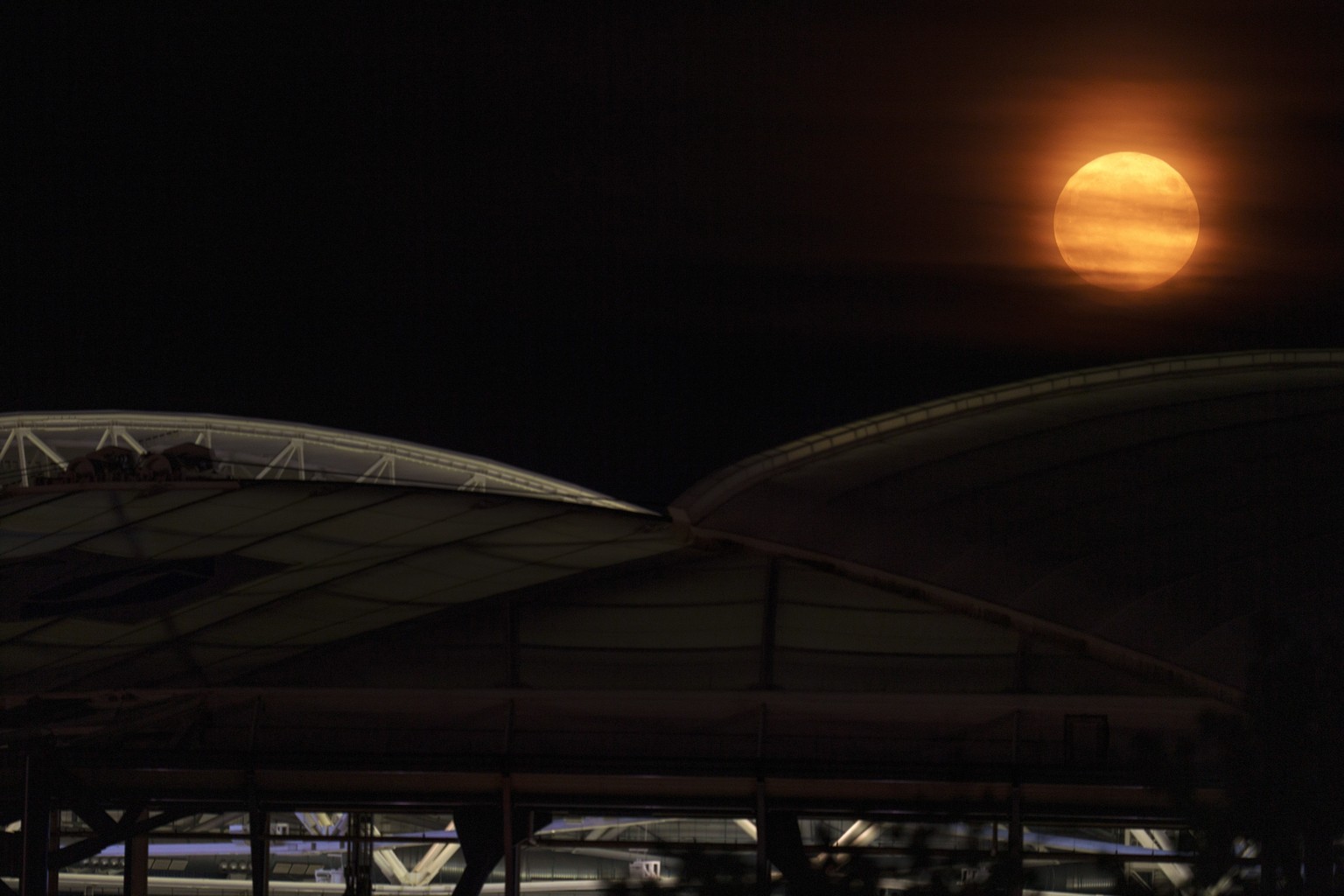 A super moon rises behind Arthur Ashe Stadium at the Billie Jean King National Tennis Center during the second round of the U.S. Open tennis championships, Wednesday, Aug. 30, 2023, in New York. A rar ...