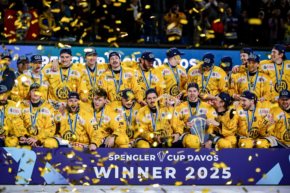 epa12619238 HC Davos players celebrate with the trophy after winning the Spengler Cup finals ice hockey match between US Collegiate Selects and HC Davos, in Davos, Switzerland, 31 December 2025. EPA/M ...