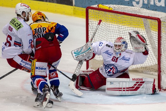 EHC Kloten Stuermer Denis Hollenstein, Mitte, gegen SC Rapperswil-Jona Lakers Torhueter Melvin Nyffeler und Martin Ness, links, im dritten Eishockey Spiel der Ligaqualifikation der National League zwi ...