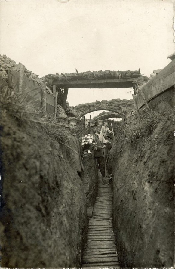 A German soldier holding a bouquet of flowers. An unexpected sight in the trenches