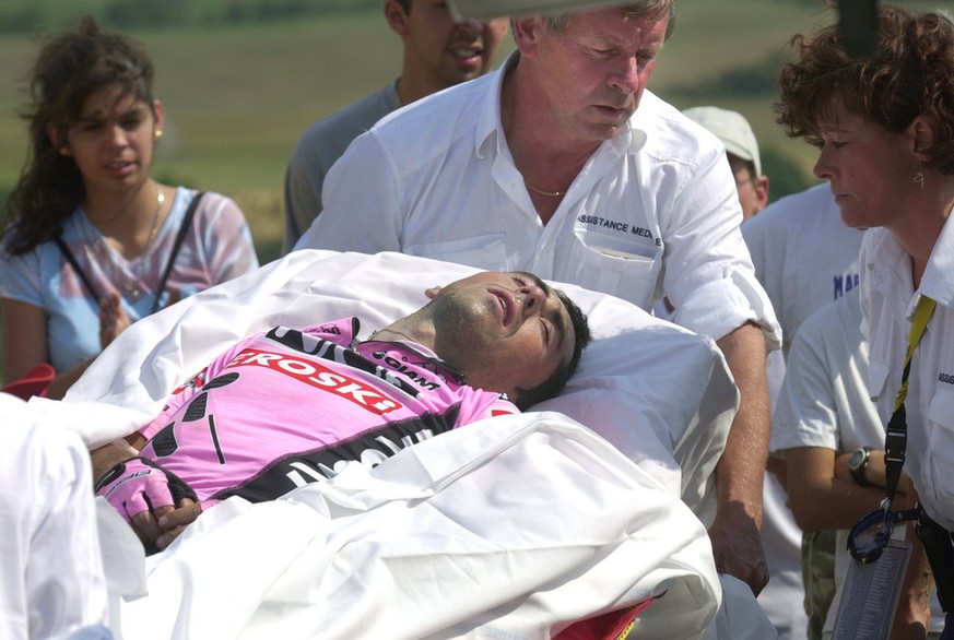 Tour de France chief doctor Gerard Portes, behind, pulls Joseba Beloki of Spain, lying on a stretcher, as he is evacuated to the Gap hospital, after falling in a turn four kilometers before the finish ...