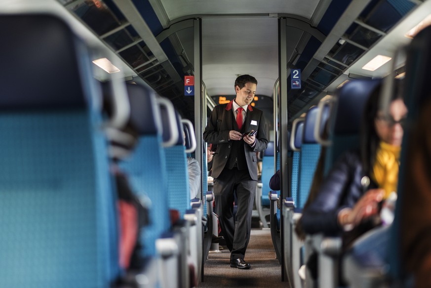 ZUM THEMA SERVICE-ABBAU DER SBB AN DER SOMMERSESSION 2017 STELLEN WIR IHNEN FOLGENDES BILDMATERIAL ZUR VERFUEGUNG  A train conductor of the Swiss Federal Railways checks passenger&#039;s tickets on a ...