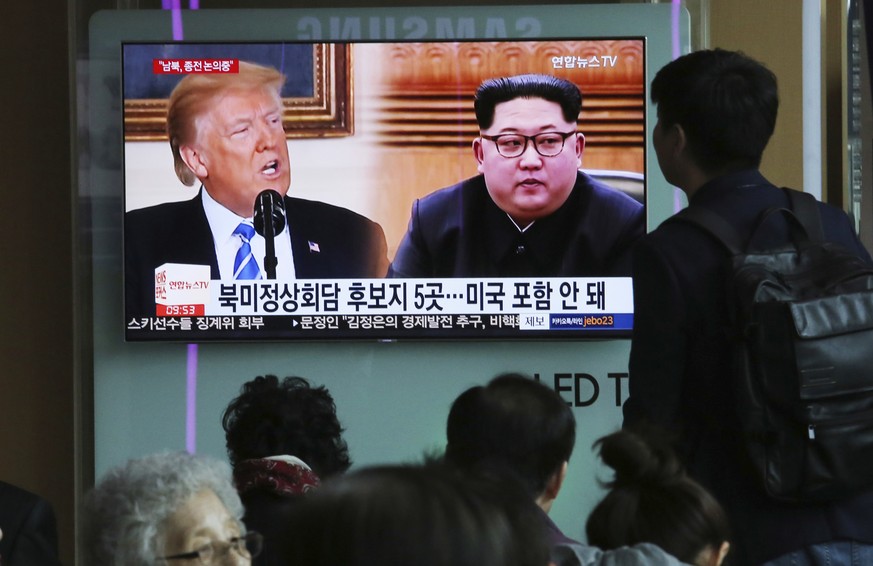 People watch a TV screen showing file footage of U.S. President Donald Trump, left, and North Korean leader Kim Jong Un during a news program at the Seoul Railway Station in Seoul, South Korea, Wednes ...