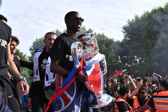 epa13007003 Ousmane Dembele of Paris Saint-Germain carries the trophy during the PSG victory celebration show in Paris, France, 31 May 2026. PSG became the first French team to successfully defend the ...