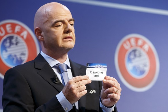 UEFA General Secretary Gianni Infantino shows a ticket of Swiss club FC Basel, during the drawing of the games for the Champions League 2015/16 play-offs, at the UEFA Headquarters in Nyon, Switzerland ...