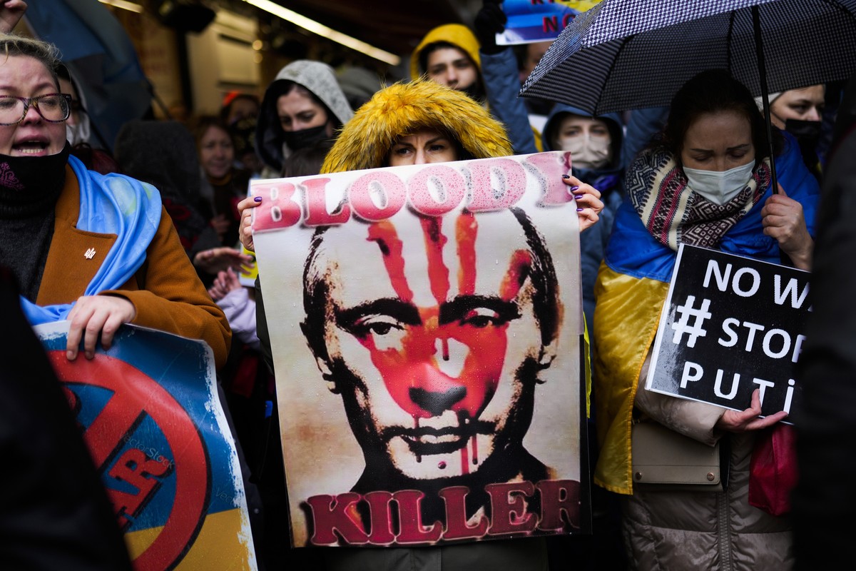 People hold banners and shout slogans during a small protest outside the Russian consulate in Istanbul, Turkey, Thursday, Feb. 24, 2022, after Russian troops launched an attack on Ukraine. (AP Photo/F ...