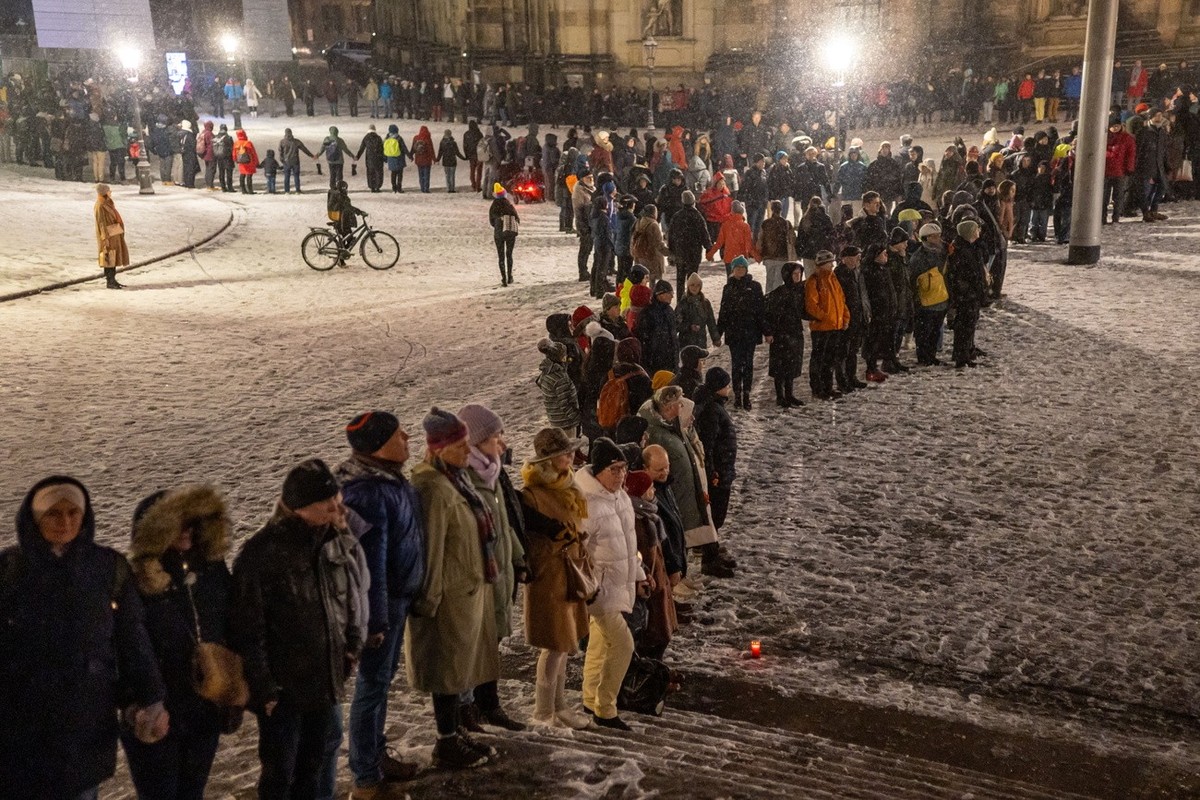 epa11893593 People join hands to form a human chain as part of commemorations for the 80th anniversary of the destruction of Dresden during World War II, in central Dresden, Germany, 13 February 2025. ...