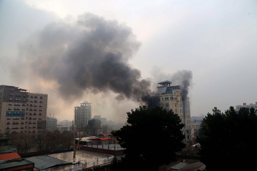 epaselect epa10361754 Smoke billows from a guest house after an attack in Kabul, Afghanistan, 12 December 2022. The Afghan capital was rocked by a loud blast and gunfire on 12 December, near one of th ...